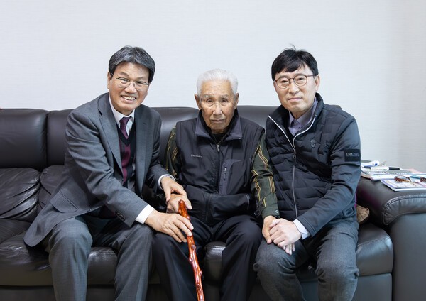 100세를 맞은 화성면 농암리 어르신께 장수지팡이(청려장)를 전달하며 축하 인사를 나누고 있는 김돈곤 군수(왼쪽)와 조형섭 화성면장(오른쪽). /청양군